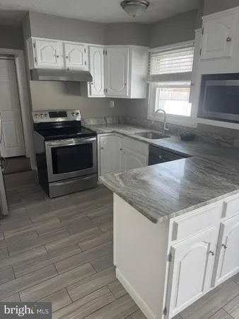 a kitchen with granite countertop a stove and a sink