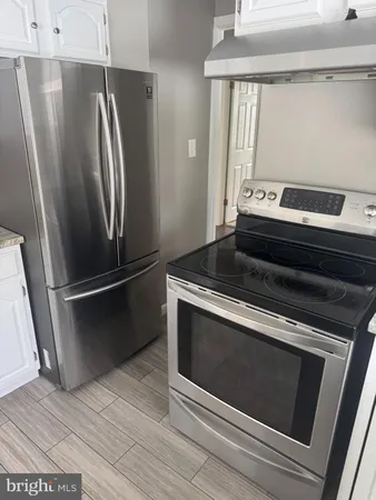 a metallic refrigerator freezer sitting in a kitchen