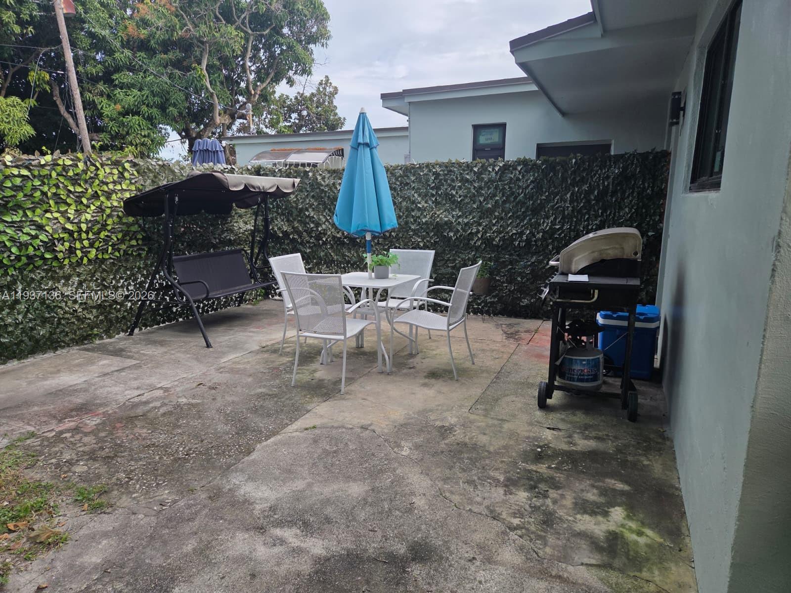 2979 Northwest 88th Street, Unit 1 Miami, FL 33147 - Photo 7 of 7 a view of a patio with table and chairs and potted plants