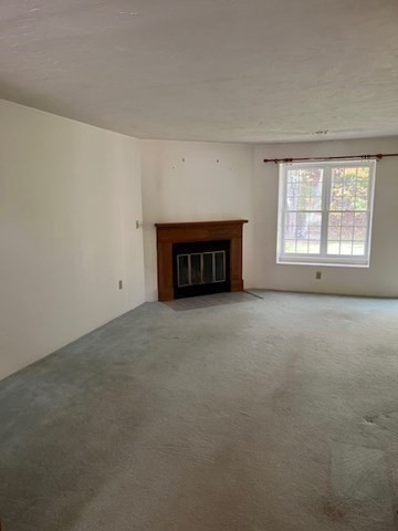 920 Ridgefield Circle, Unit C Clinton, MA 01510 - Photo 6 of 26 an empty room with a fireplace and windows