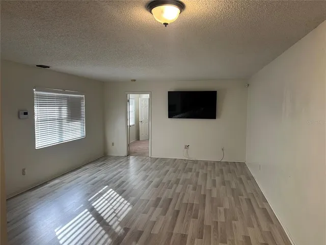 a view of a livingroom with wooden floor and bench