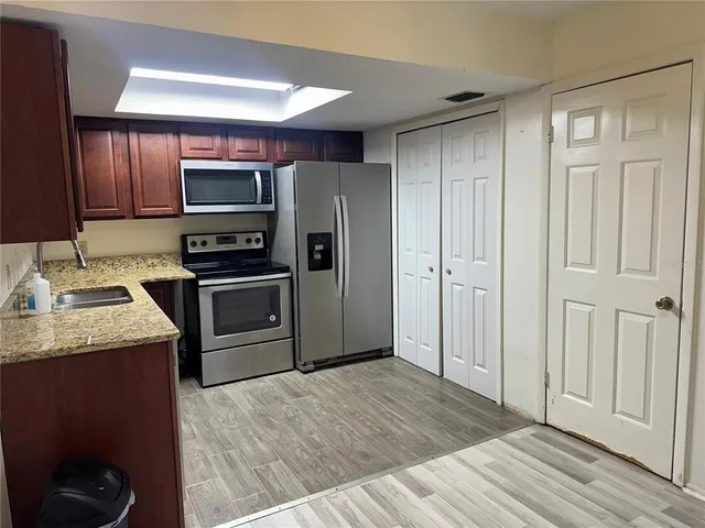 a kitchen with stainless steel appliances granite countertop a refrigerator stove and sink