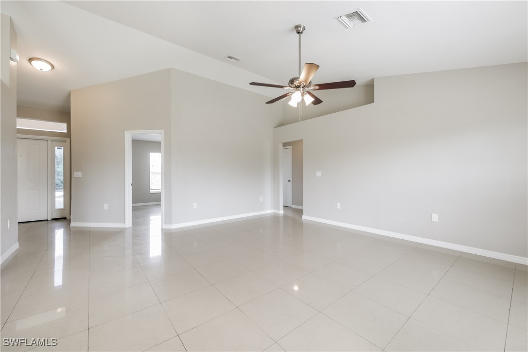 404 Willowbrook Drive Lehigh Acres, FL 33972 - Photo 2 of 16 a view of an empty room with a chandelier fan