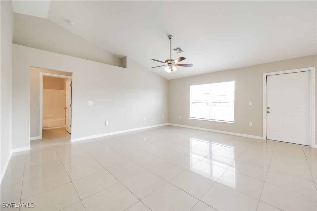 404 Willowbrook Drive Lehigh Acres, FL 33972 - Photo 4 of 16 an empty room with windows and chandelier fan