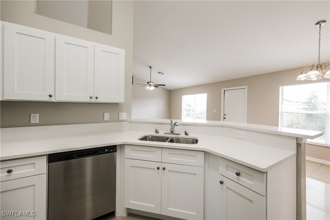 404 Willowbrook Drive Lehigh Acres, FL 33972 - Photo 8 of 16 a kitchen with white cabinets and a window