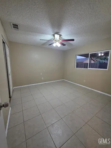 an empty room with windows and fan