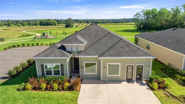 a aerial view of a house with a yard and potted plants