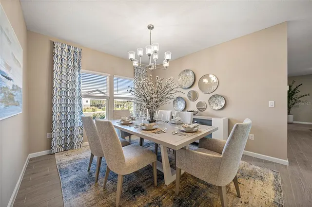 a view of a dining room with furniture a chandelier and wooden floor