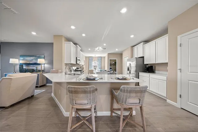 a kitchen with kitchen island cabinets and chairs