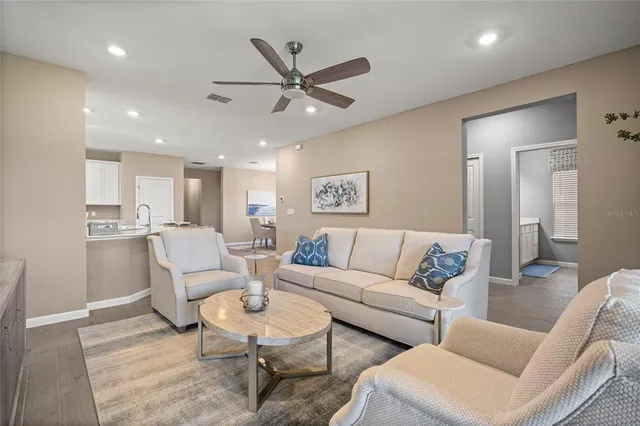a living room with furniture and a view of kitchen