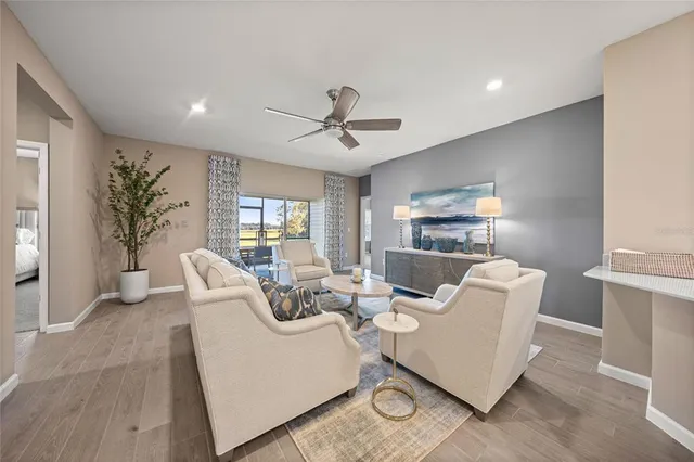 a living room with furniture and a large window with wooden floor