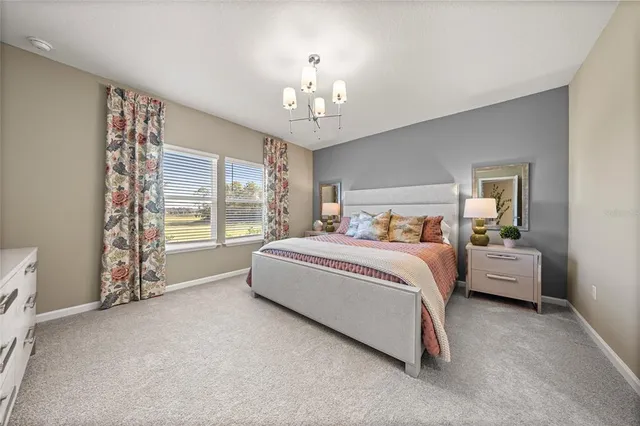 a spacious bedroom with a bed and a chandelier