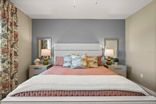 a bedroom with a large bed and a potted plant