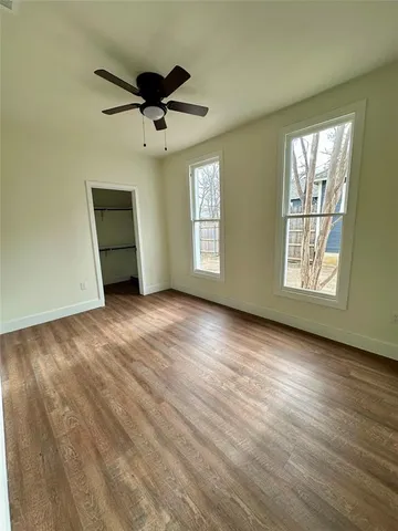 a view of a livingroom with wooden floor and a ceiling fan