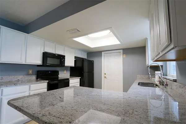 a kitchen with a sink a stove top oven and cabinets