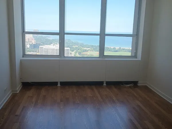 a view of empty room with wooden floor