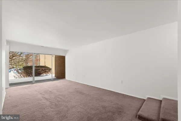 an empty room with glass door and windows