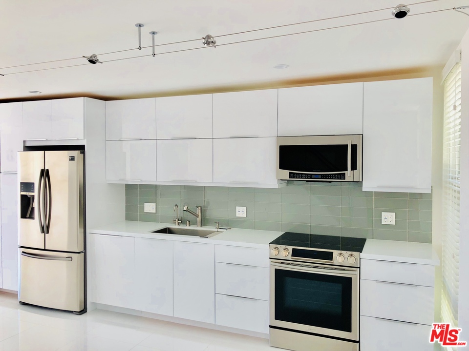 a kitchen with a stainless steel appliances white cabinets and a refrigerator