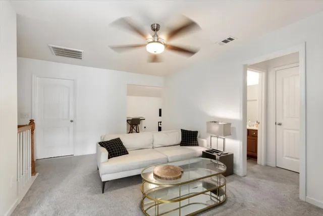 a living room with furniture and a ceiling fan