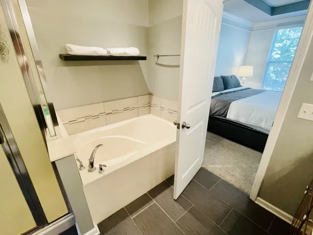 a bathroom with a tub a sink and a shower