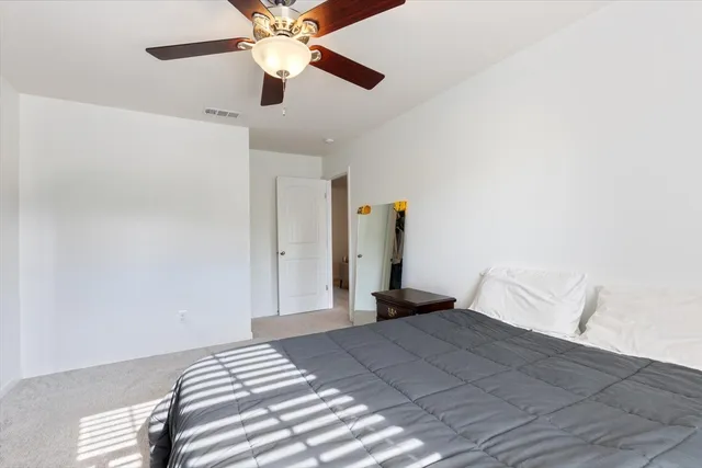 a bedroom with a bed and a ceiling fan