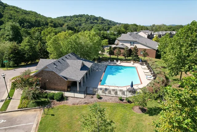 an aerial view of a house with swimming pool and mountains