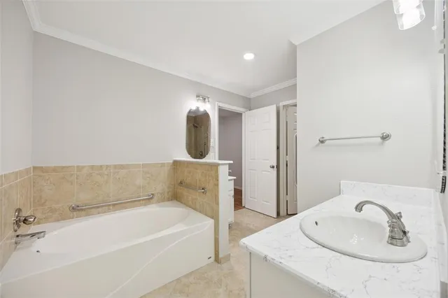 a bathroom with a tub sink and mirror