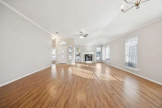 a view of a livingroom with wooden floor and a kitchen