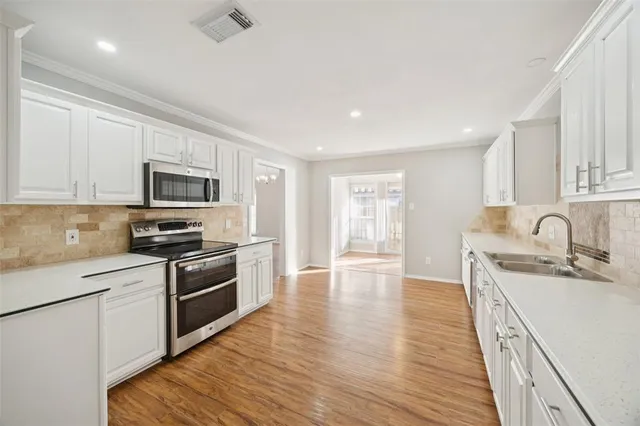 a kitchen with stainless steel appliances granite countertop a sink dishwasher stove top oven and refrigerator