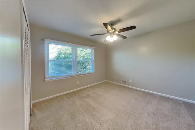 an empty room with a window and a fan