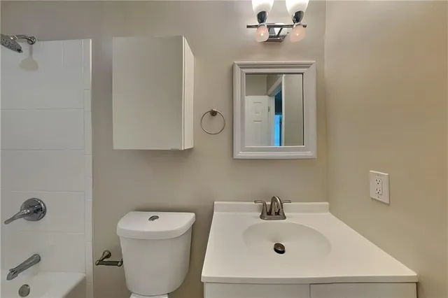 a bathroom with a sink mirror and toilet