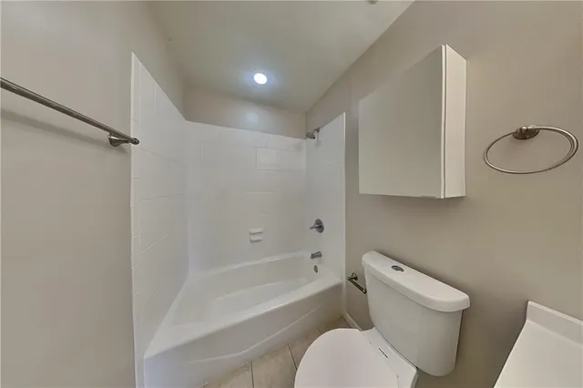 a white toilet sitting next to a bath tub