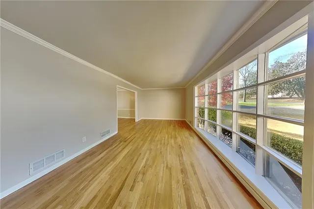 a view of a room with wooden floor and windows