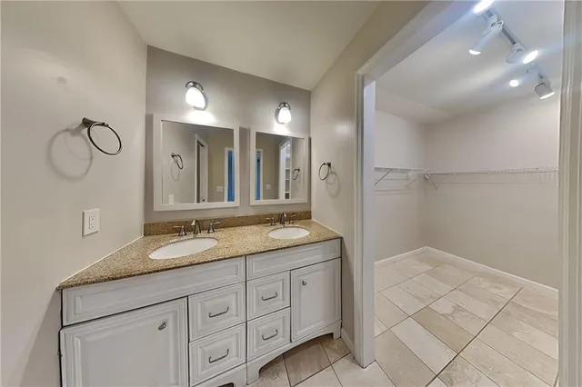 a bathroom with a granite countertop sink a mirror and a shower