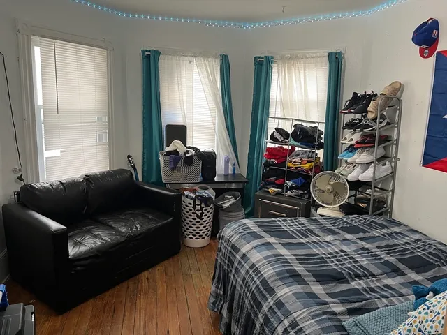 a bedroom with furniture and a wooden floor