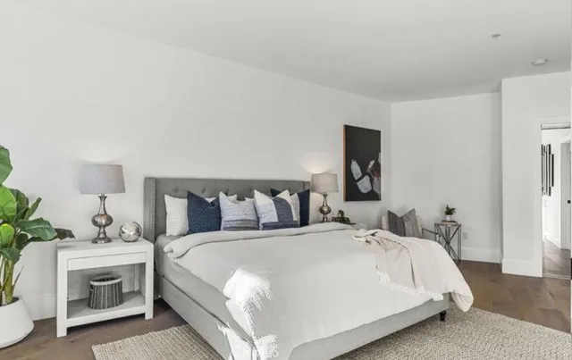 a bedroom with a bed couch and large window