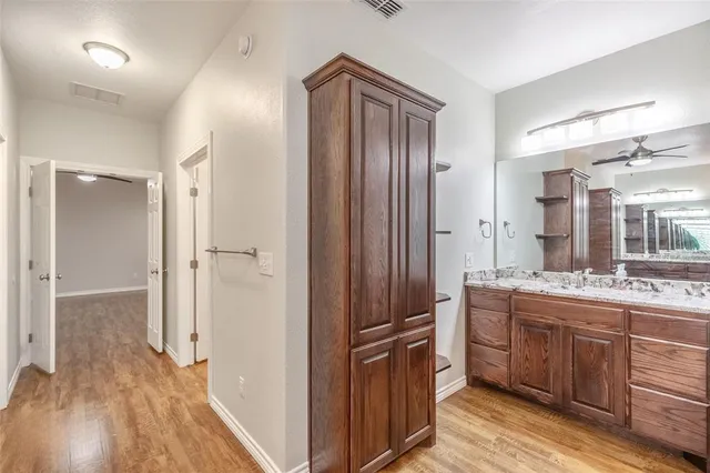 an empty room with wooden floor and ceiling fan