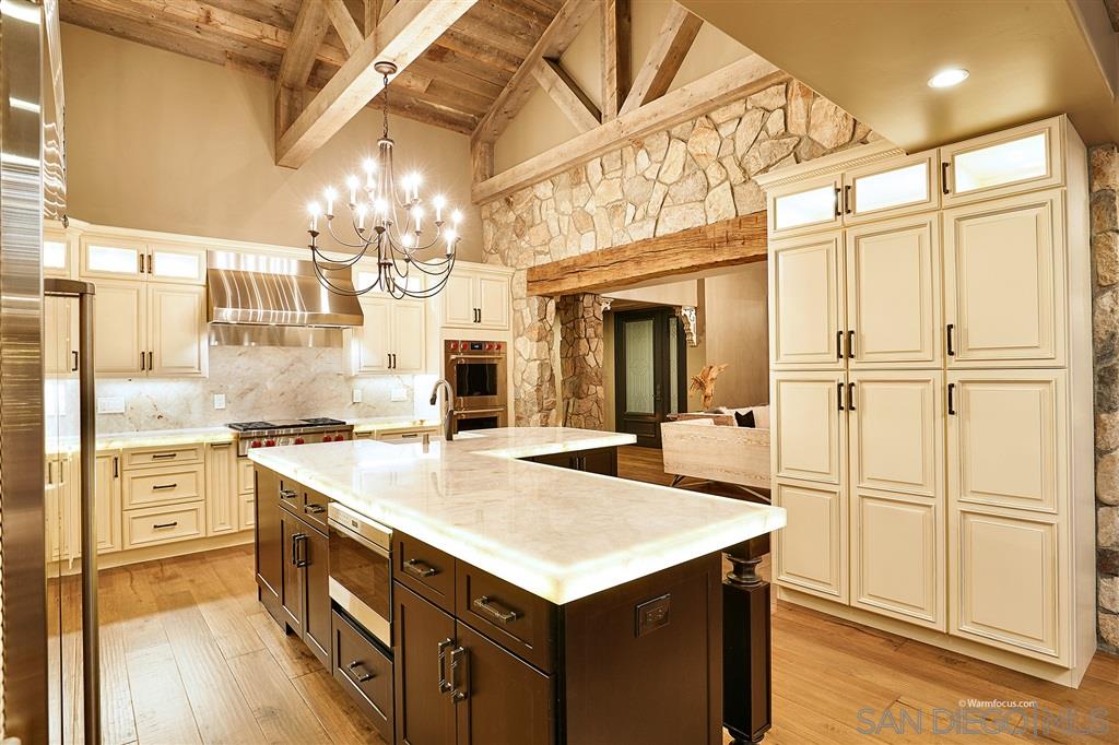 Designer gourmet kitchen features Wolf, sub-zero & Bosch appliances, custom cabinets, oak lined ceilings, hickory wood flooring