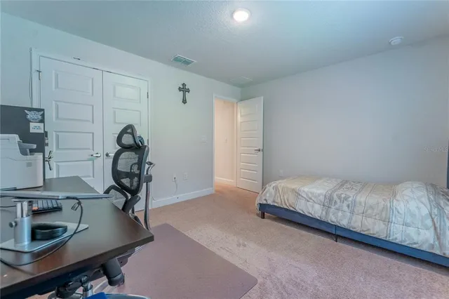 a bedroom with a bed and a desk in it