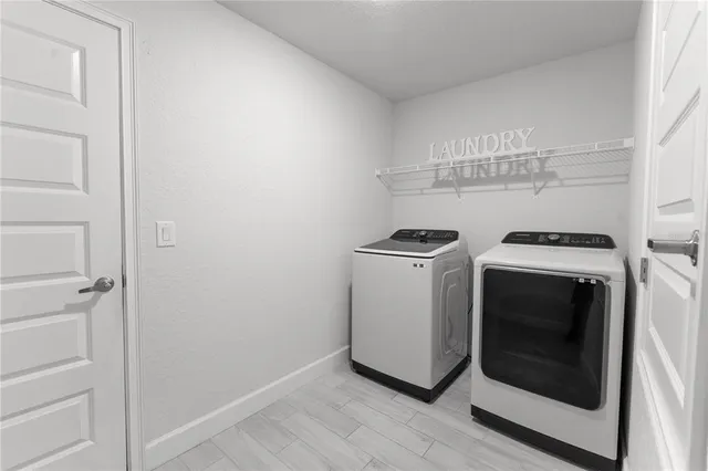 a utility room with wooden floor washer and dryer