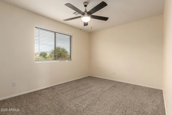 an empty room with a window and a fan