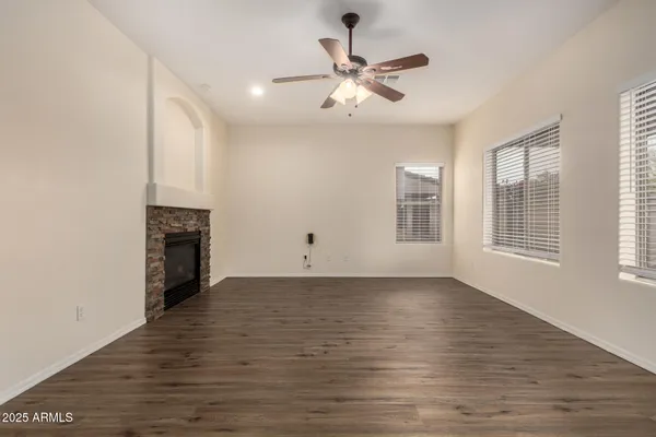 a view of a kitchen with a stove wooden floor a fireplace and a window