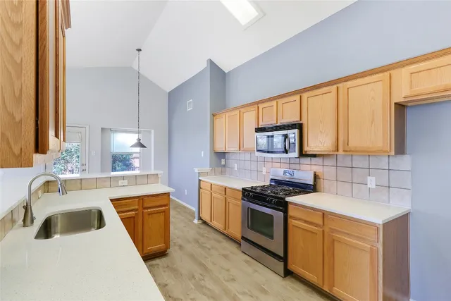 a kitchen with a sink stove top oven and refrigerator
