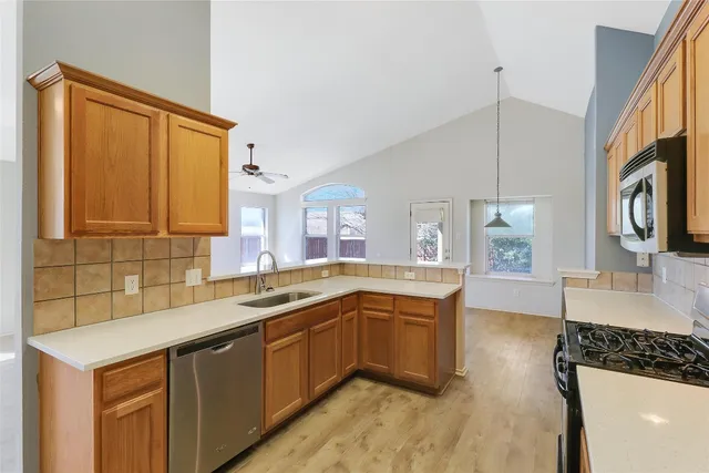 a kitchen with a sink a stove and cabinets