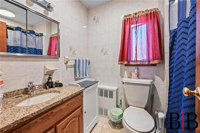 a bathroom with a granite countertop toilet sink and mirror