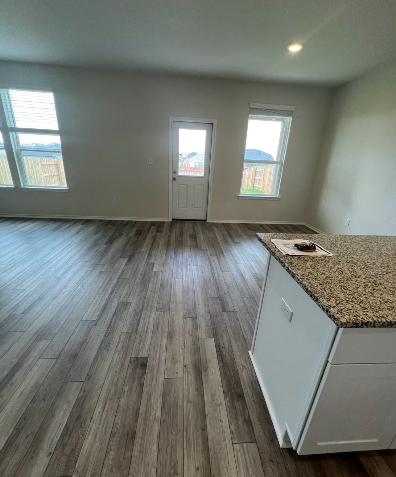 499 Tree Nut Loop Buda, TX 78610 - Photo 5 of 33 Granite counters complement the rich wood flooring in this versatile dining space.