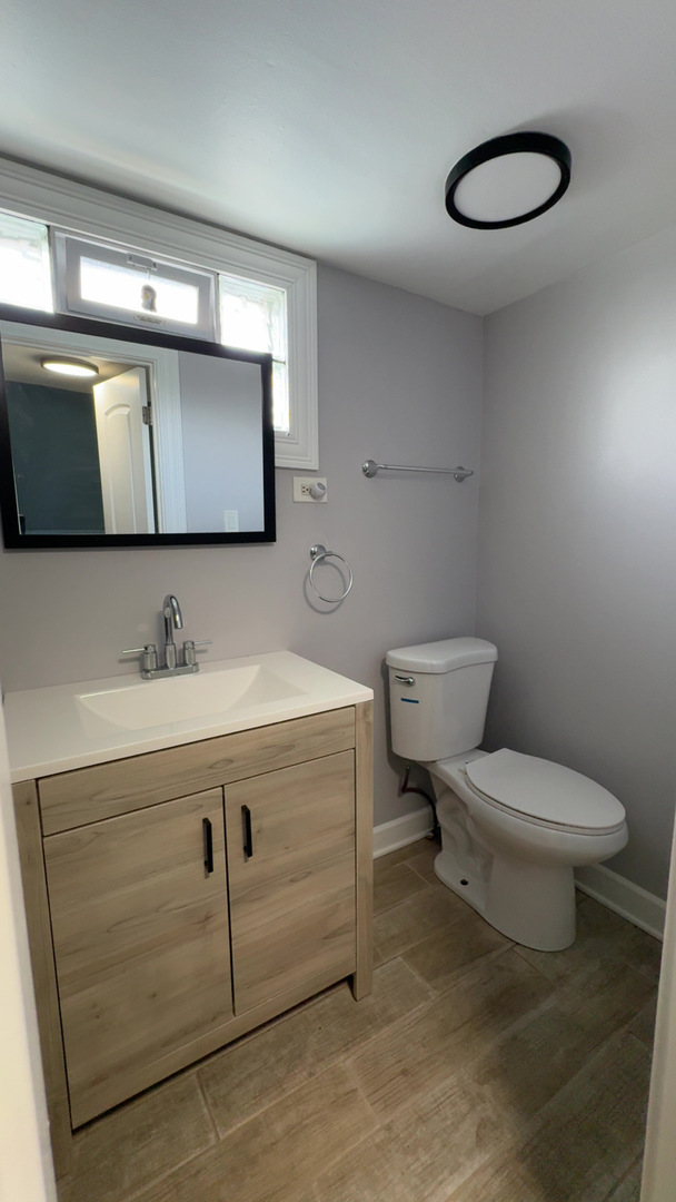 1429 South 49th Avenue, Unit 3 Cicero, IL 60804 - Photo 3 of 8 a bathroom with a toilet sink and mirror