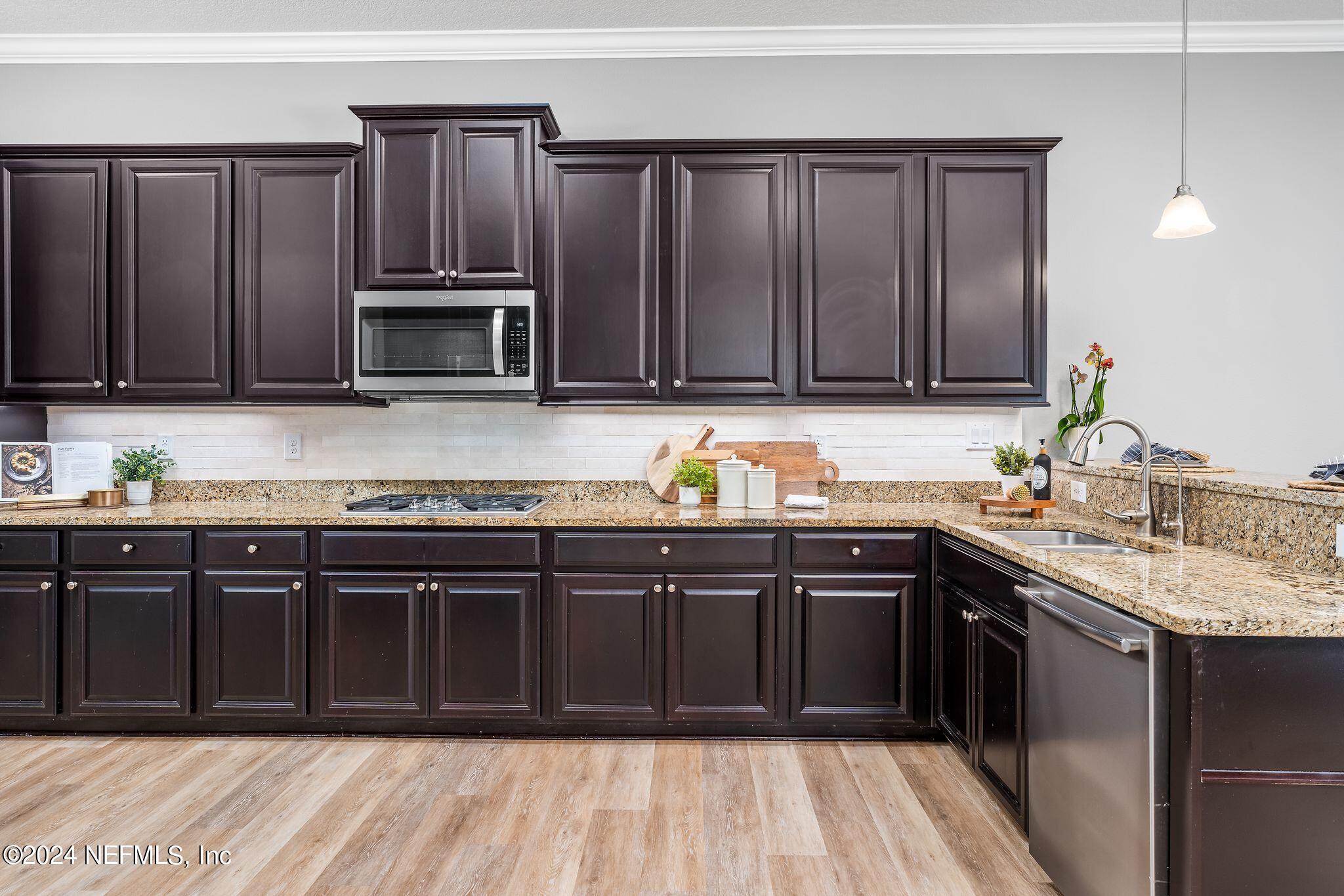 206 Medio Drive St. Augustine, FL 32095 - Photo 14 of 57 a kitchen with granite countertop wooden cabinets a sink and a oven
