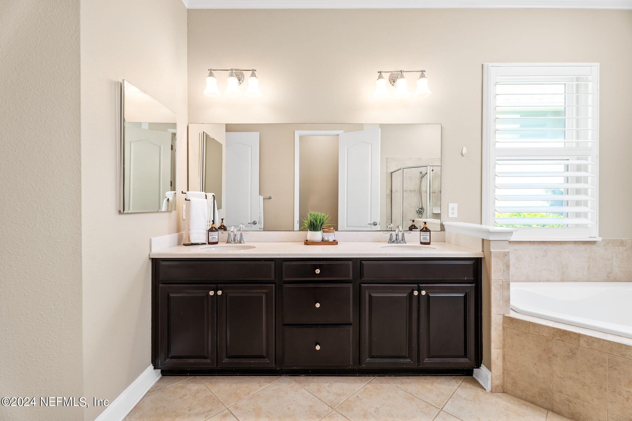 206 Medio Drive St. Augustine, FL 32095 - Photo 19 of 57 a bathroom with a granite countertop double vanity sink and mirror with window