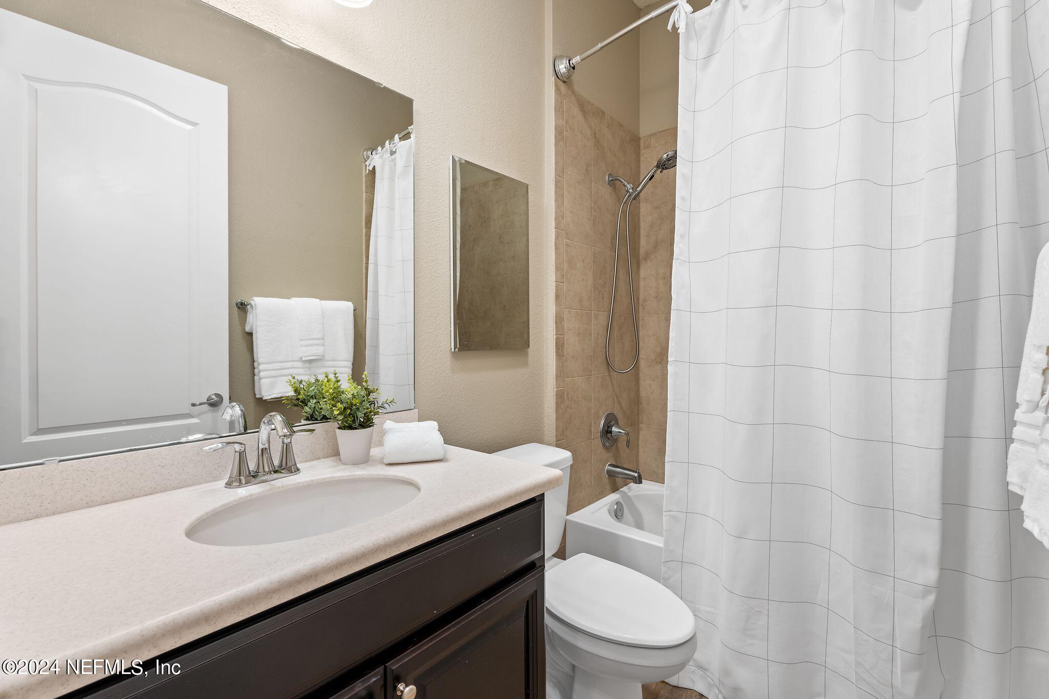206 Medio Drive St. Augustine, FL 32095 - Photo 24 of 57 a bathroom with a granite countertop sink toilet a mirror and shower